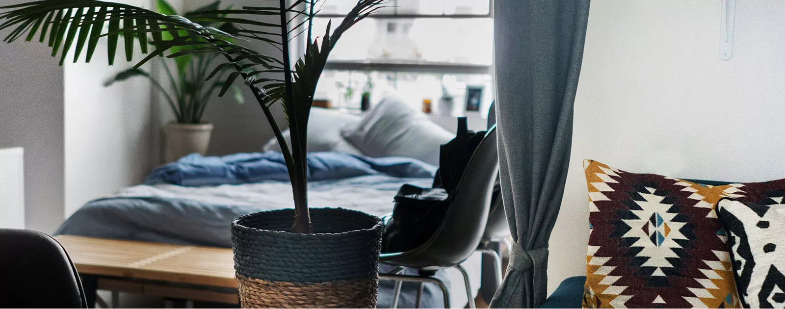 Chambre aux textiles bleus et naturels avec plantes et lumière douce